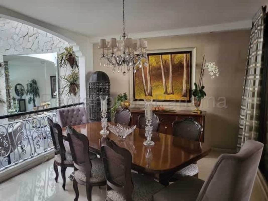 Formal dining room with chandelier and large painting in classic El Carmen Panama house