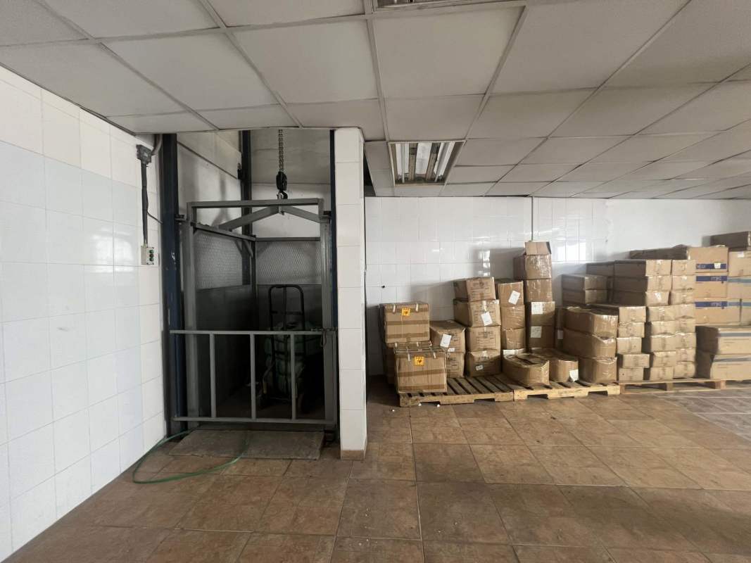 Modern commercial lobby with glass doors, tiled floors, and red chairs in Betania Panama