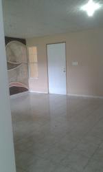 Empty living room with tiled floor, beige walls and door rental house Panama