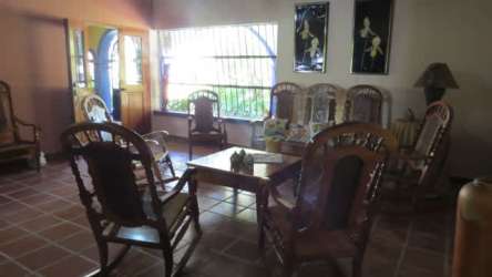Living room with wooden chairs and garden views Coronado beach house