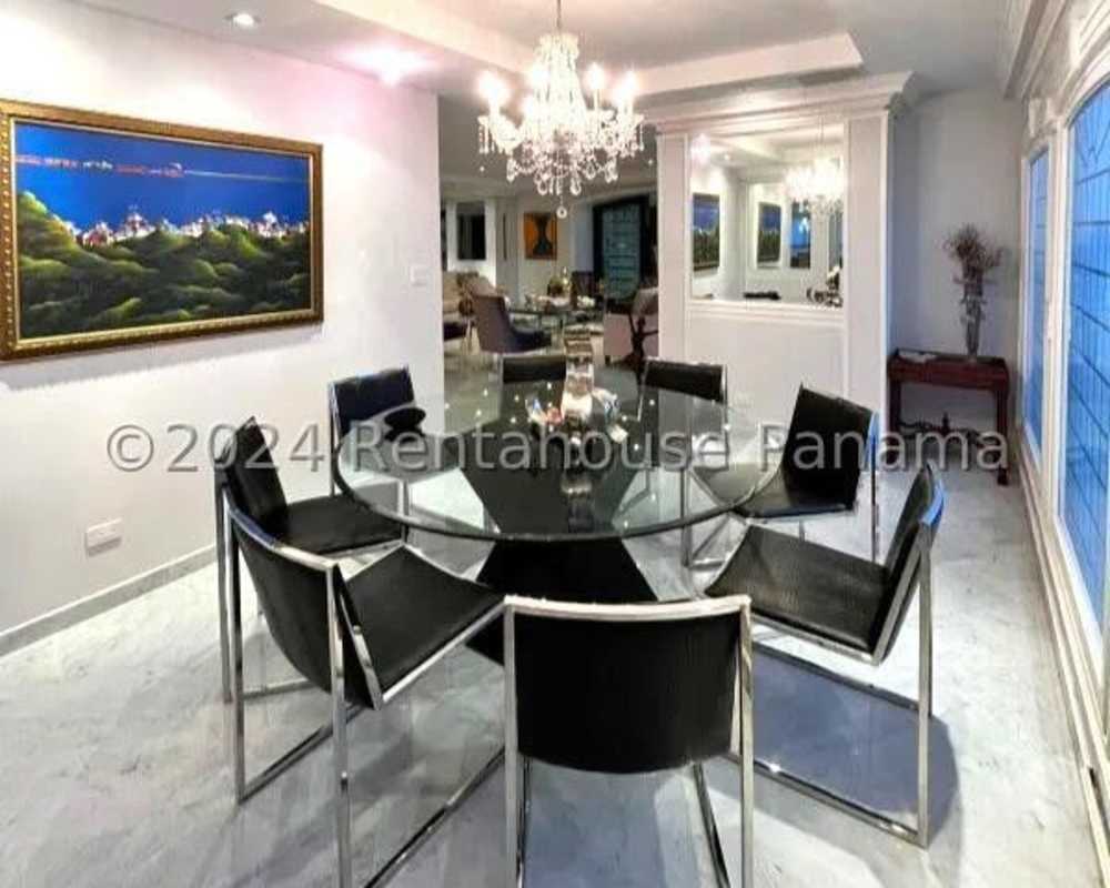 Luxurious dining area with marble floors, chandelier, and waterfront city view PH Punta del Sol Panama