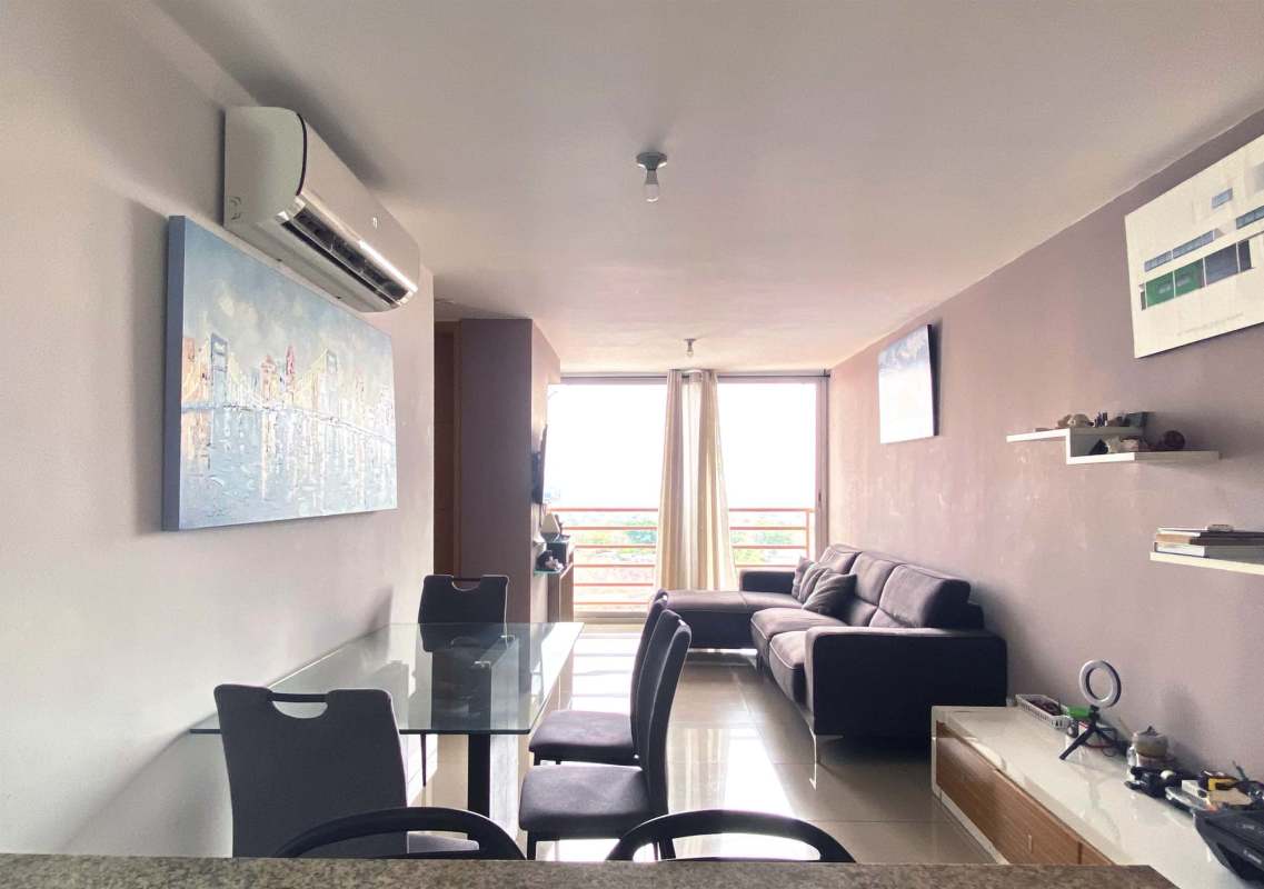 Minimalist living space with large windows, dining, gray sofa, Panama City views in PH 4 Islas