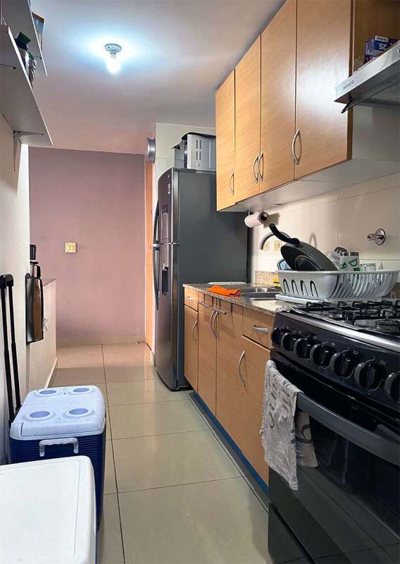 Apartment kitchen with granite countertops, light wood cabinetry, refrigerator, stove in PH 4 Islas Panama
