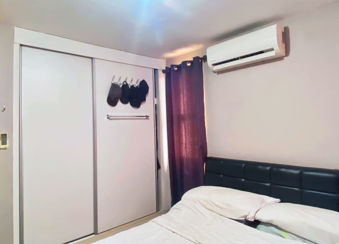 Bedroom with split AC, closet and purple curtains in PH 4 Islas Panama apartment
