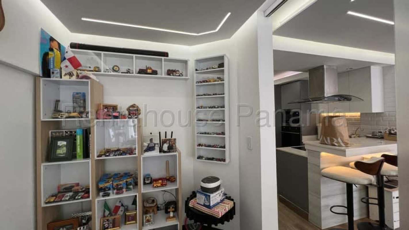 Living room with floor-to-ceiling windows overlooking garden and swimming pool in Albrook Panama