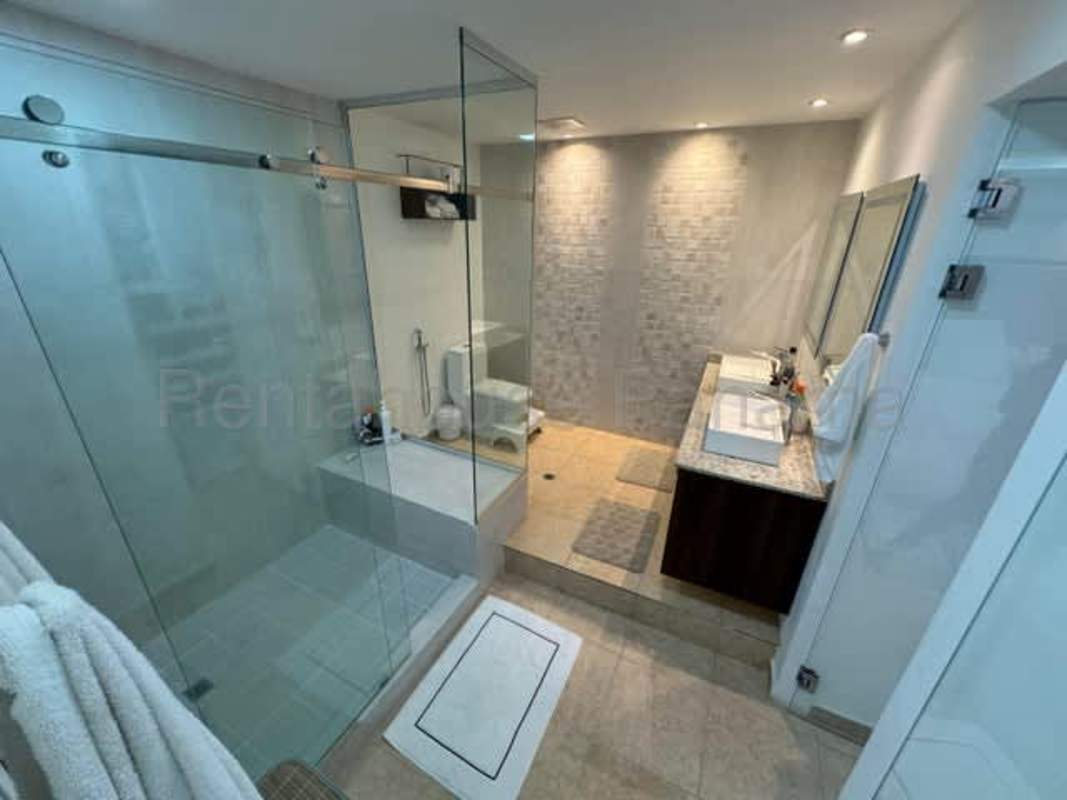 Spacious modern bathroom with glass shower enclosure and granite counter in Albrook Panama