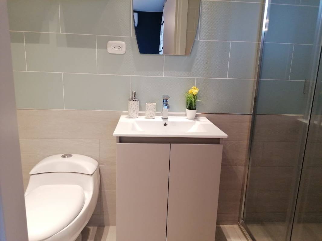 Bathroom with mirror, sink, glass shower at PH Demetra Parque Lefevre Panama