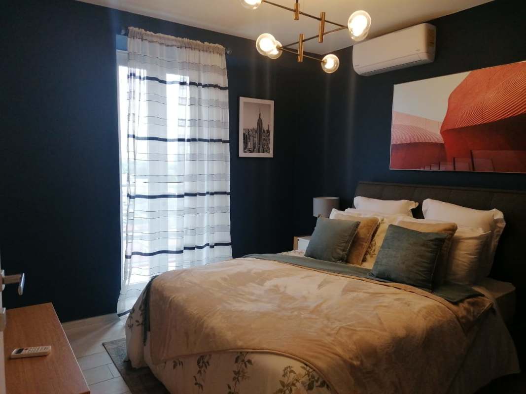 Bedroom with large window, accent wall and AC at PH Demetra Parque Lefevre Panama