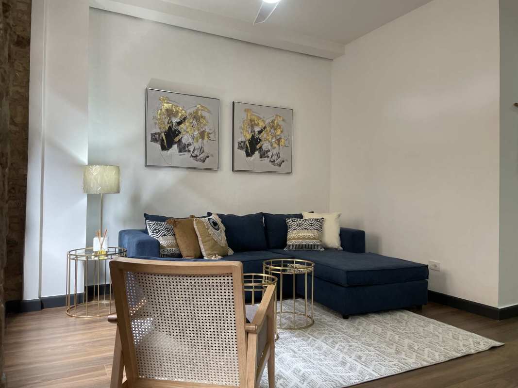 Modern open concept living dining room with wood floors, navy sofa in Casco Viejo Panama