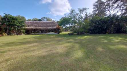 Small bathroom with beige tiled walls, toilet, and patterned tile floor in country house Penonomé Panama