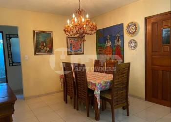 Dining room with bright yellow walls, round table, and natural lighting in Villas del Golf Chitré Panama