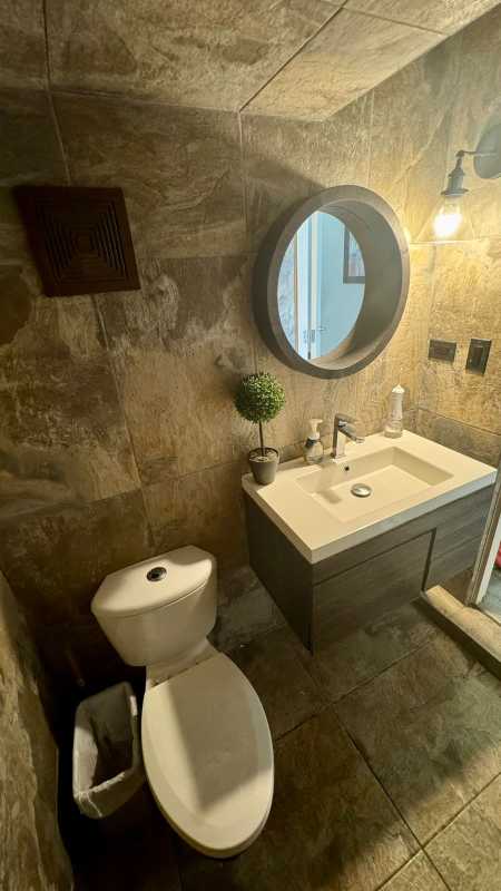 Bathroom with stone tile walls and white sink vanity in Quintas de Versalles house Panama City