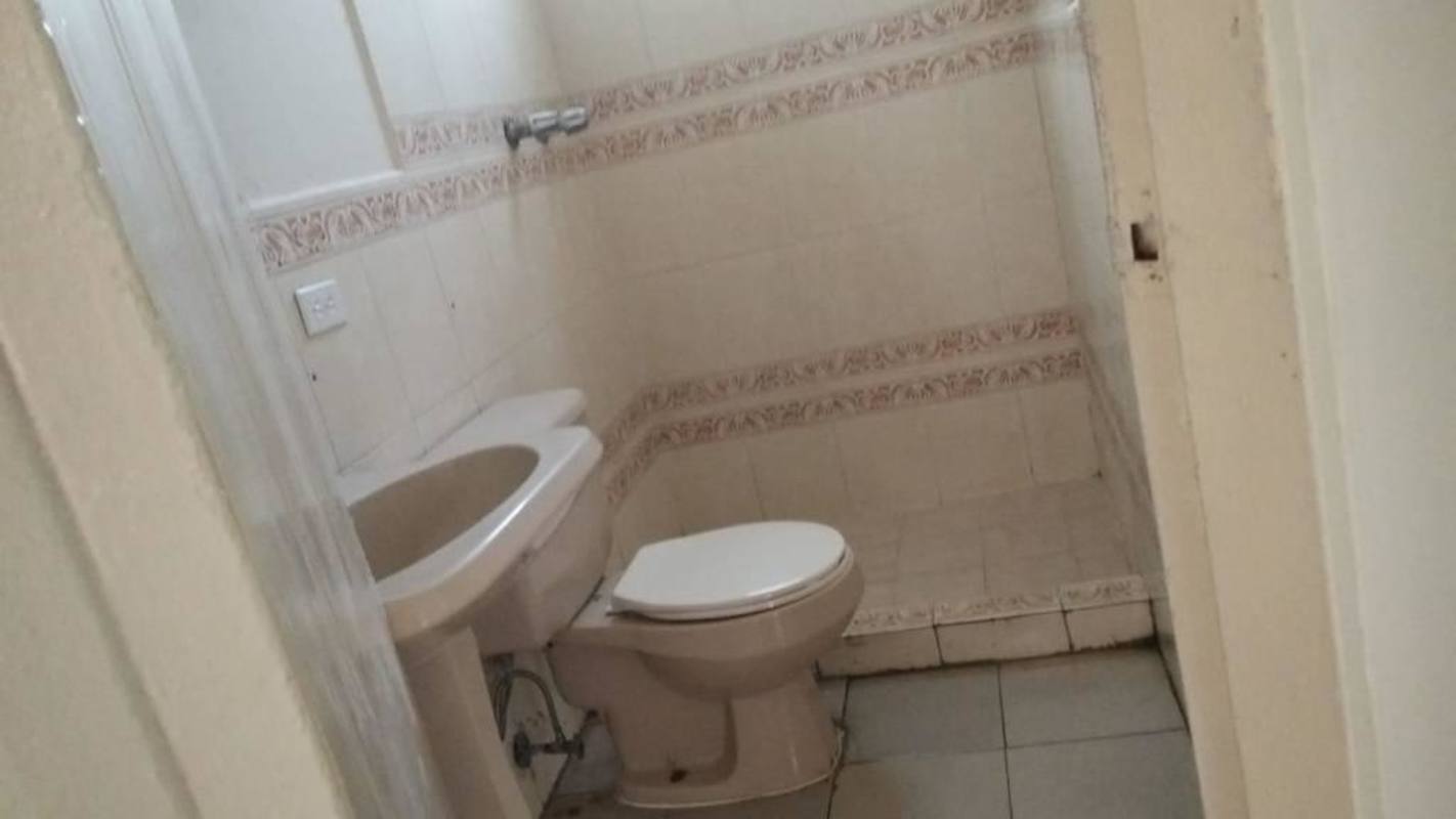 Compact bathroom with ceramic tiles and raised shower area Panama
