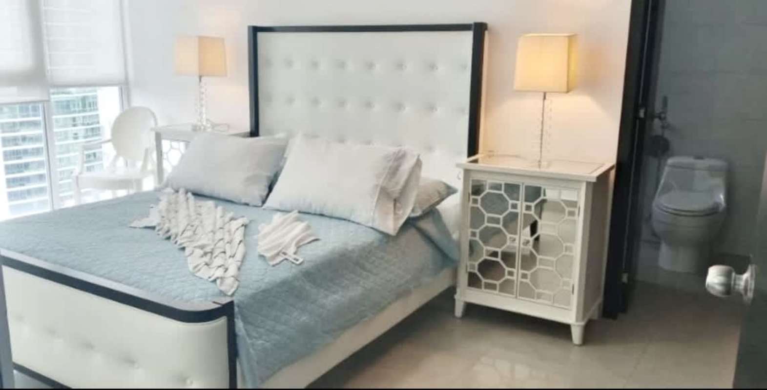 Modern living room with sectional sofa, floor-to-ceiling windows city and ocean views PH Miramar Marina Panama