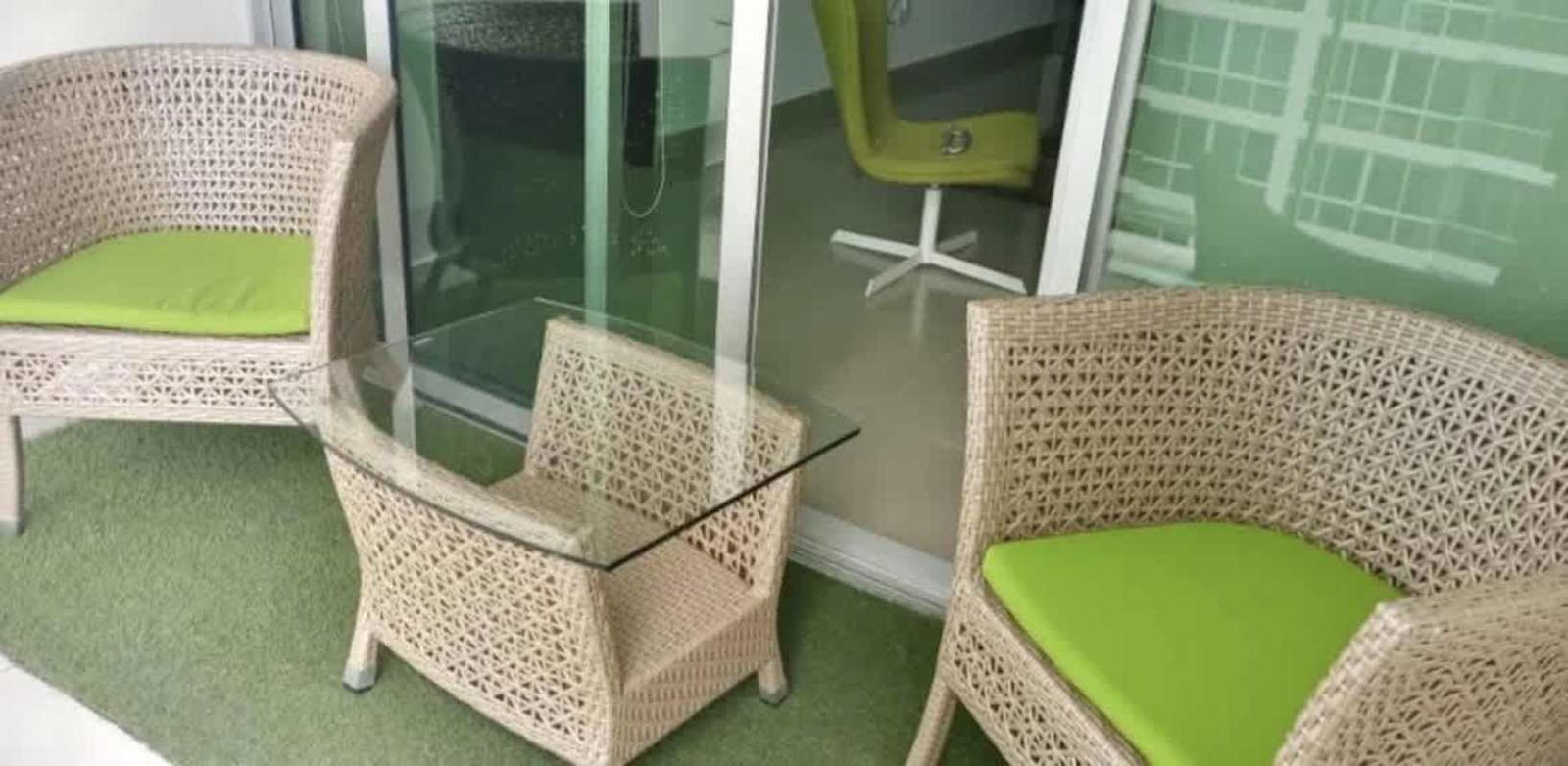 Balcony with wicker furniture, ocean and marina views at PH Miramar Marina in Panama City