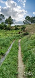 Green farmland hills dirt path forest edge Cerro Punta Volcán Panama