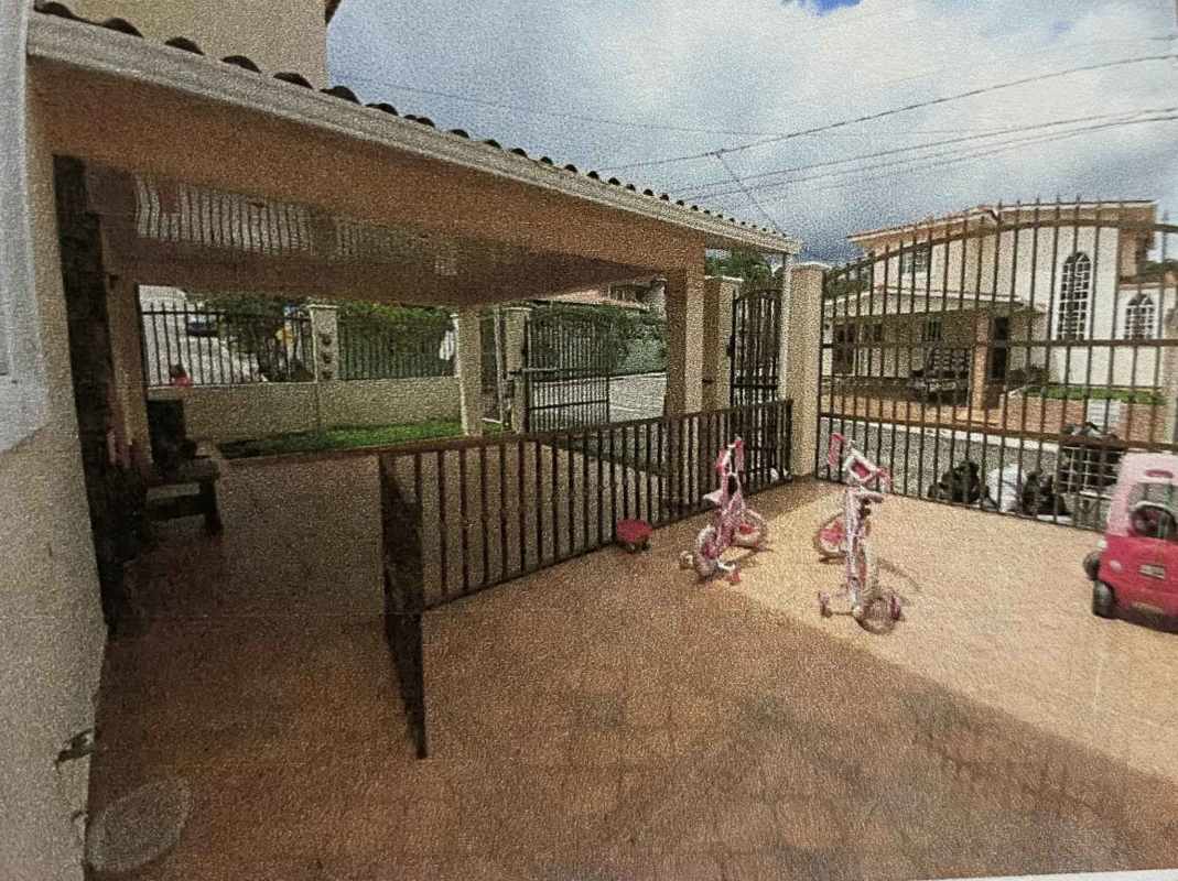 Secure gated front yard with covered patio and children toys in Villa Zaita Panama home