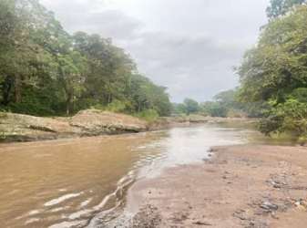 Small river surrounded by rocks, mud and lush canopy in countryside lot Nueva Gorgona Chame
