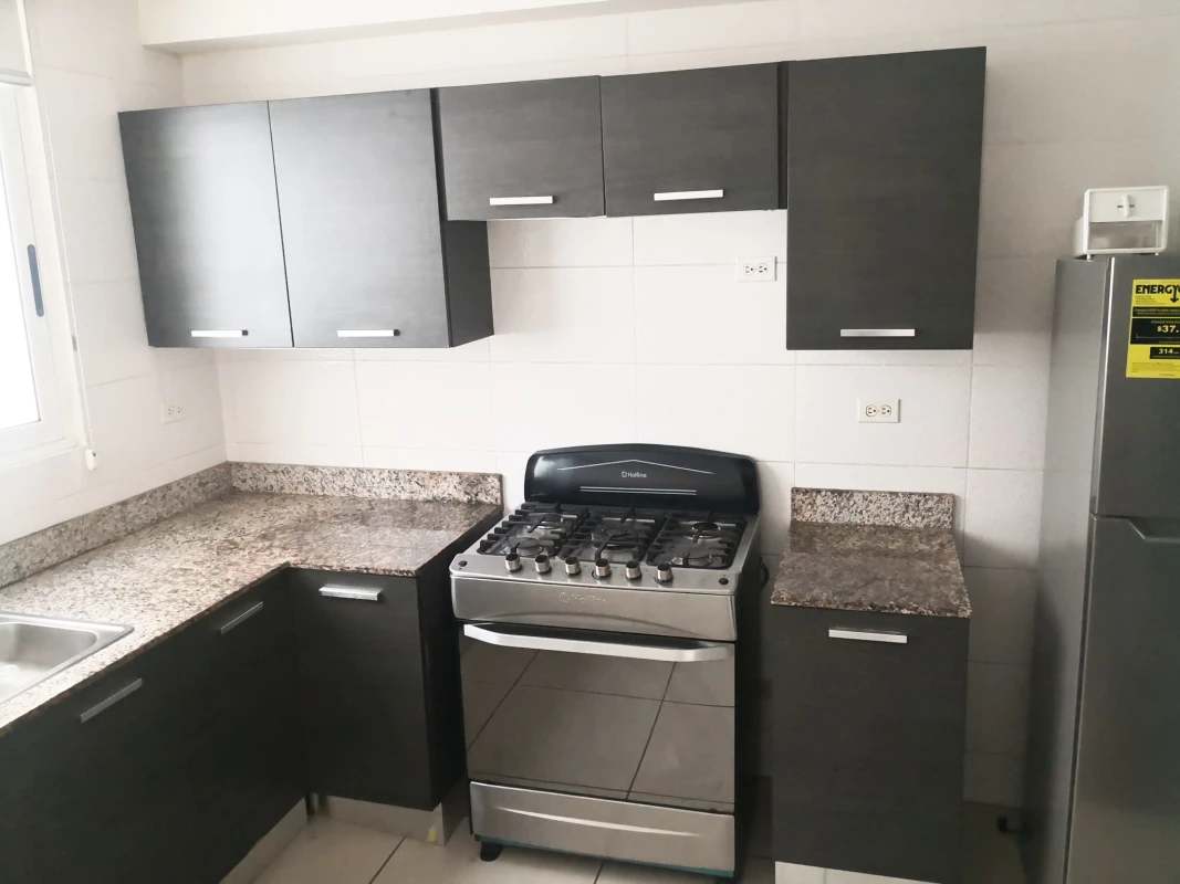 Kitchen with modern granite counters, appliances, cabinets in PH Condado Country Club Panama
