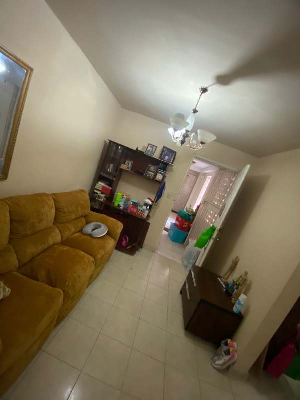 Living room with beige tiles and brown sofa in affordable Panama City condo in 12 de Octubre