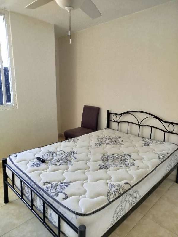 Minimalist bright bedroom with window, ceiling fan, bed and chair at PH Torre El Cangrejo Panama City