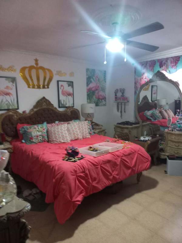 Bedroom with pink bedding, vintage tufted headboard, ceiling fan Villa Zaita