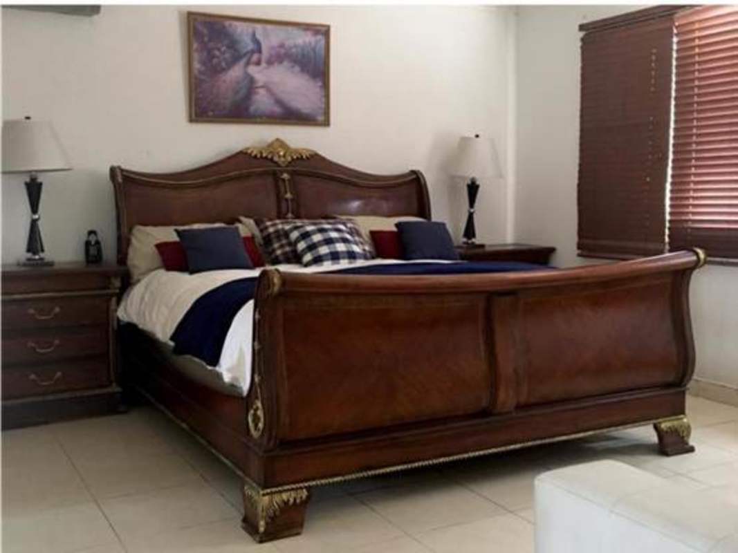 Spacious living room with brown leather sofas, big windows and fan in PH Costa Bay house Panama