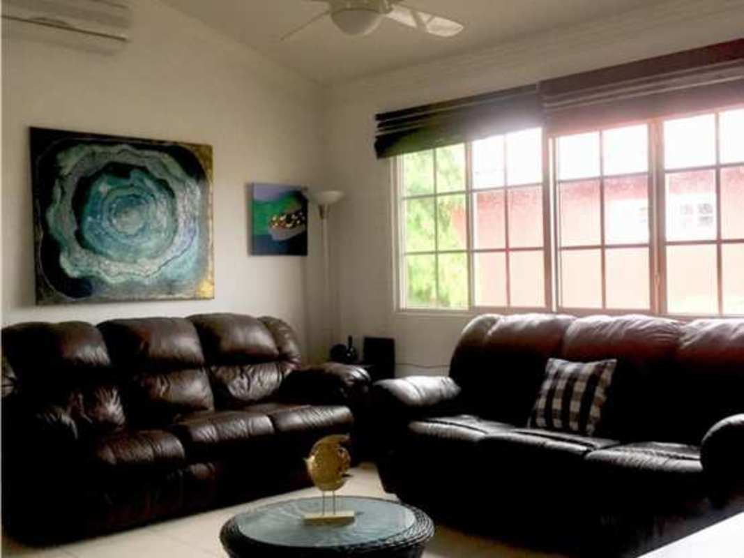 Primary bedroom with wood furnishings, large bed, lamps and tiled floor in PH Costa Bay Panama