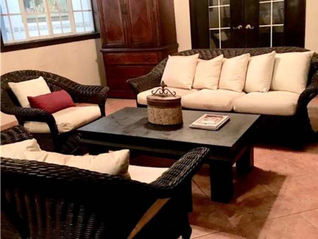 Bedroom with wooden sleigh bed, colorful decor, and large bright windows in Costa Bay Panama