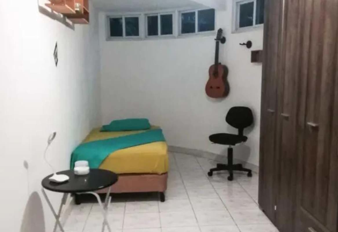 Single bedroom with desk, wardrobe, and guitar wall decor PH Cristal Park Panama