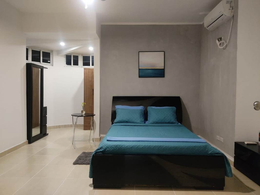 Cozy bedroom with blue bedding and wall art in PH Cristal Park Panama City