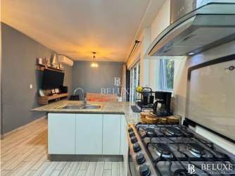 Kitchen with granite breakfast bar and connected living space at PH Aires del Mar Playa Caracol Panama