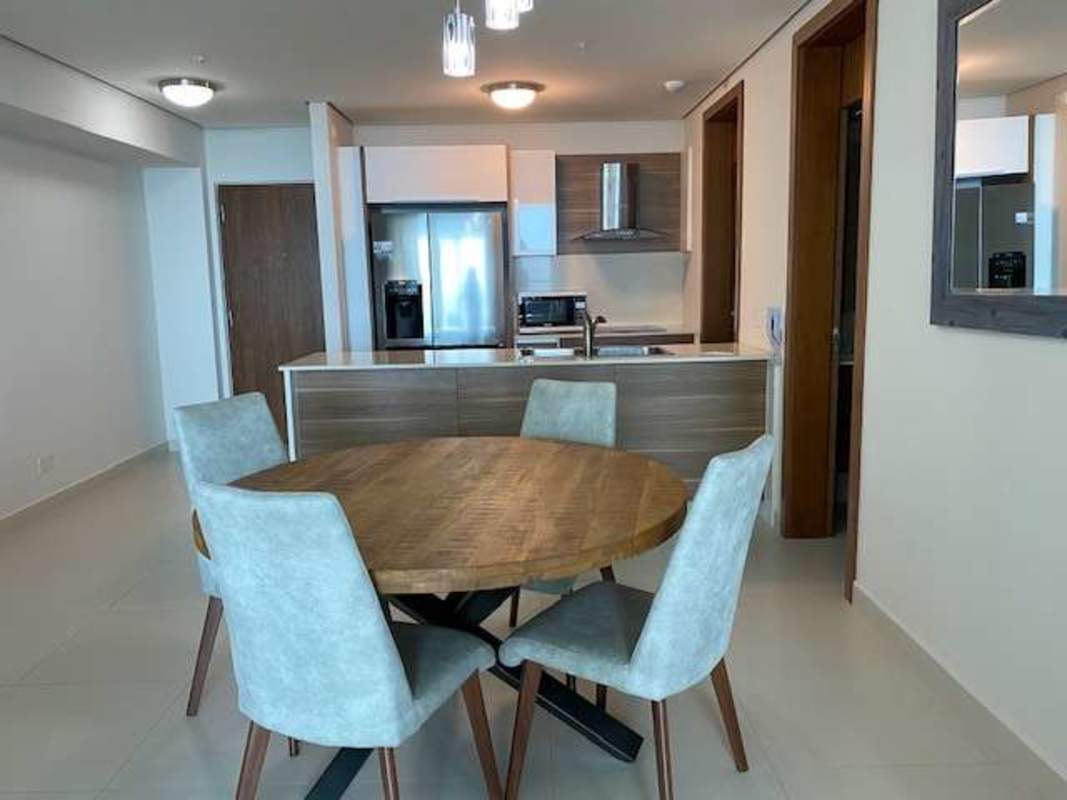 Dining area integrated with modern kitchen in luxury Parkside condo Costa del Este Panama