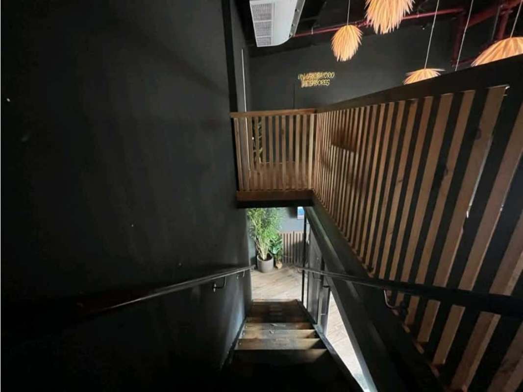 Black and wood modern staircase with pendant lights and indoor plant in commercial space San Francisco Panama