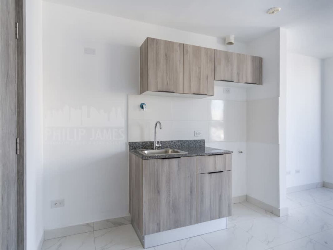 Bedroom in PH The Gray with large window and skyline view, ensuite bathroom in modern Panama apartment
