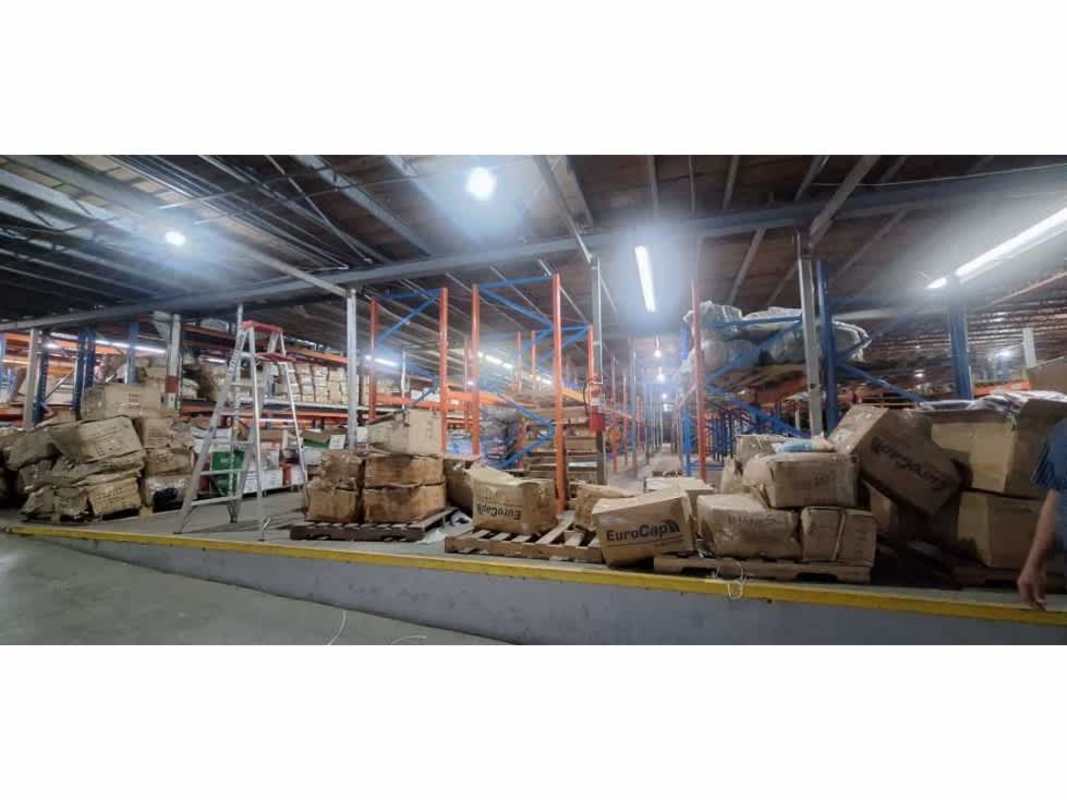 Large warehouse storage area with metal racks, pallets, and step ladder in Panama City