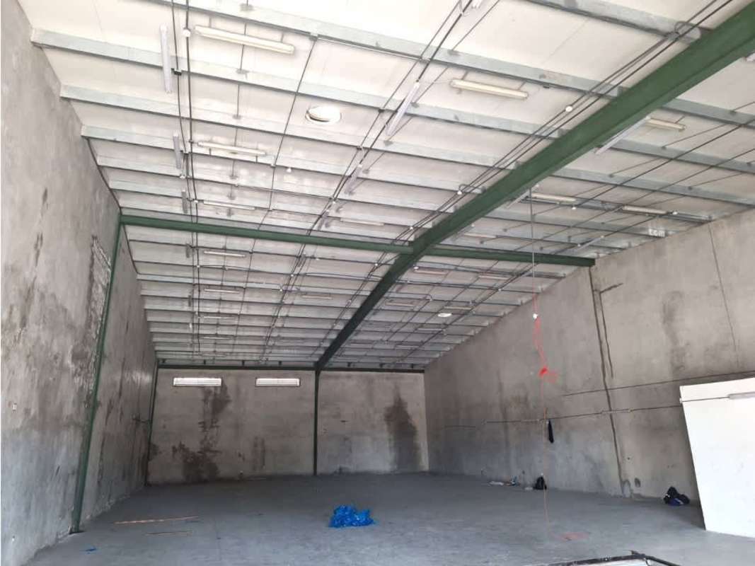 Vacant warehouse space with high clearance concrete flooring and lighting