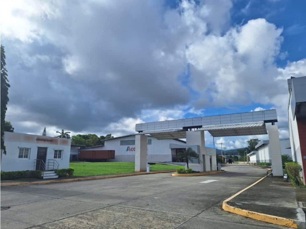 Entrance gate and security checkpoint with industrial warehouses in background