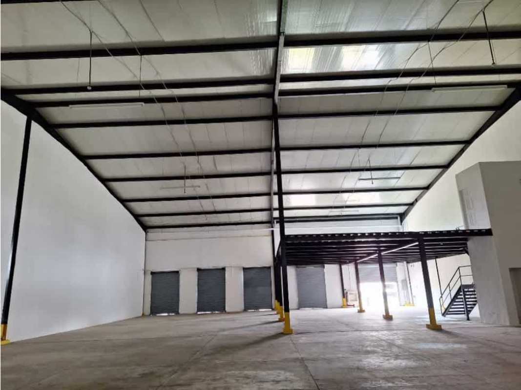 Interior view of warehouse with exposed steel beams, mezzanine level, and concrete floor in Pacora Panama