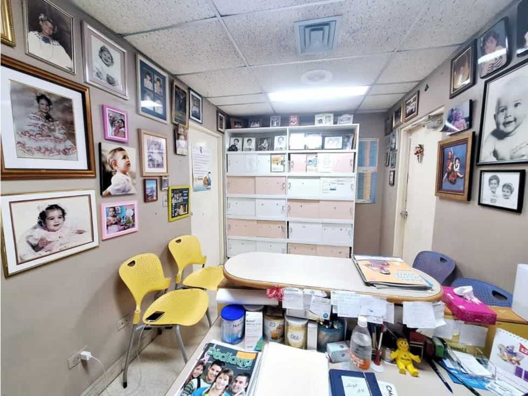 Small bathroom with beige tiles, sink, toilet, skyline window in Consultorios Paitilla Panama City