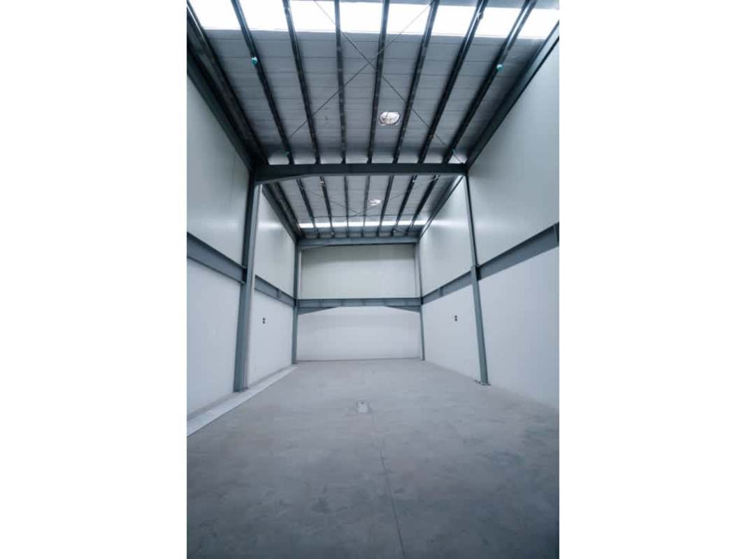 Empty warehouse space with concrete floors, skylights and metal roof beams at Panama Business Center