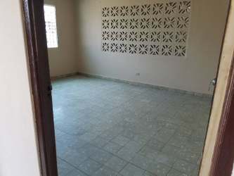 Exterior view yellow house with porch metal security bars small garden Barrio Colón Panama