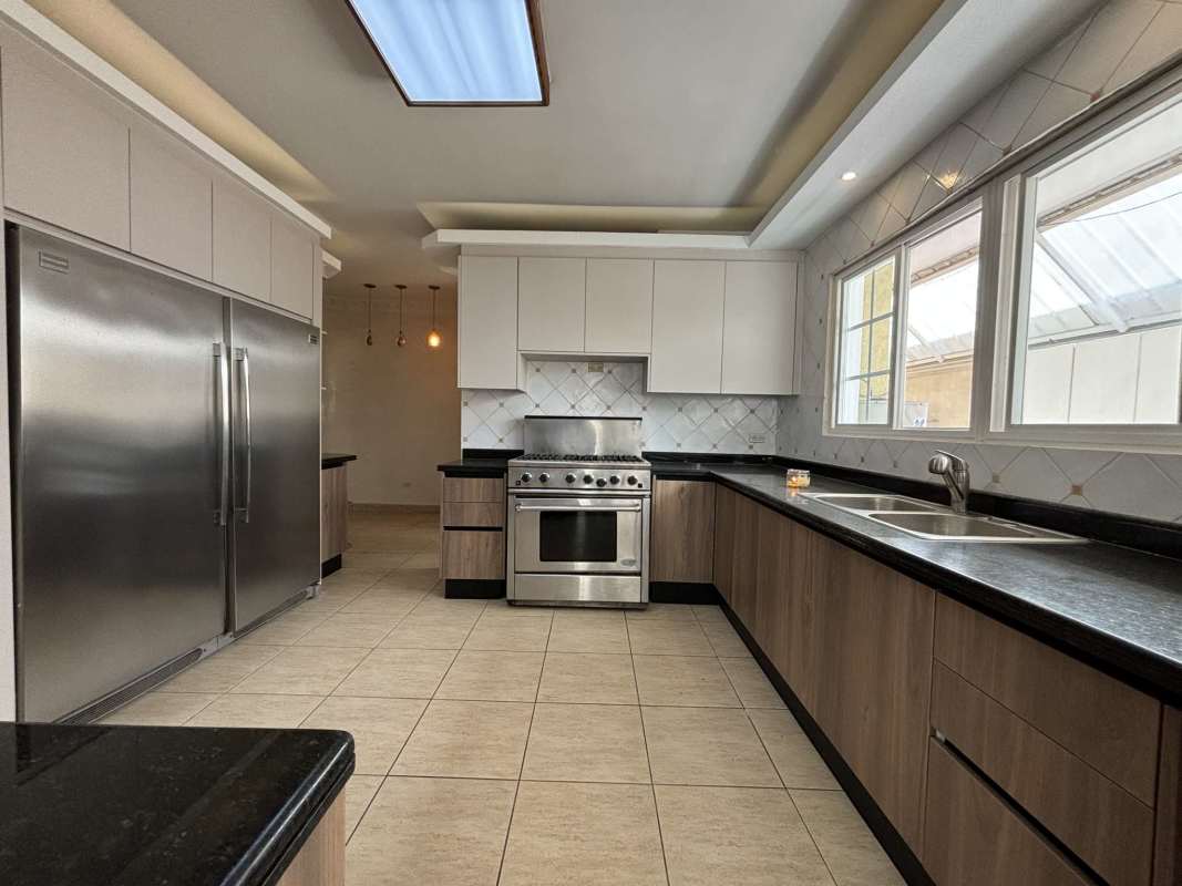 Spacious kitchen with stainless steel appliances, granite countertops, wood cabinets in Costa Dorada Costa del Este Panama