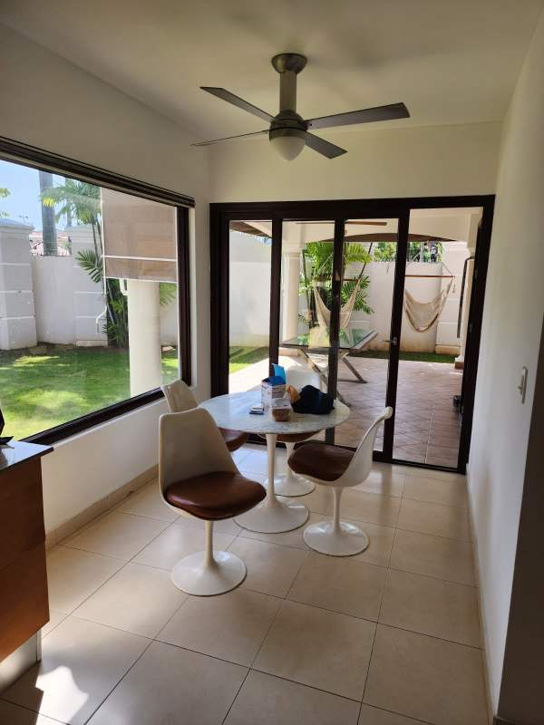 Elegant two-story house with Mediterranean tile roof, arched entry, palms Costa del Este Panama City