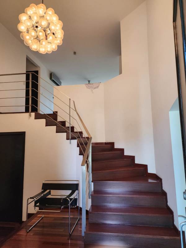 Elegant staircase with metal railing, chandelier, hardwood floors Costa del Este home