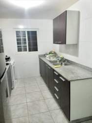 Small kitchen with tiled walls, cabinets, stove and refrigerator in house for rent Nuevo Chorrillo Arraiján