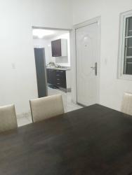 Dining space with table and kitchen with cabinets in affordable rental Nuevo Chorrillo Arraiján