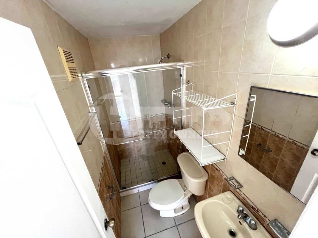 Traditional kitchen with marble-style countertops, wooden cabinets in PH Mar del Sur apartment