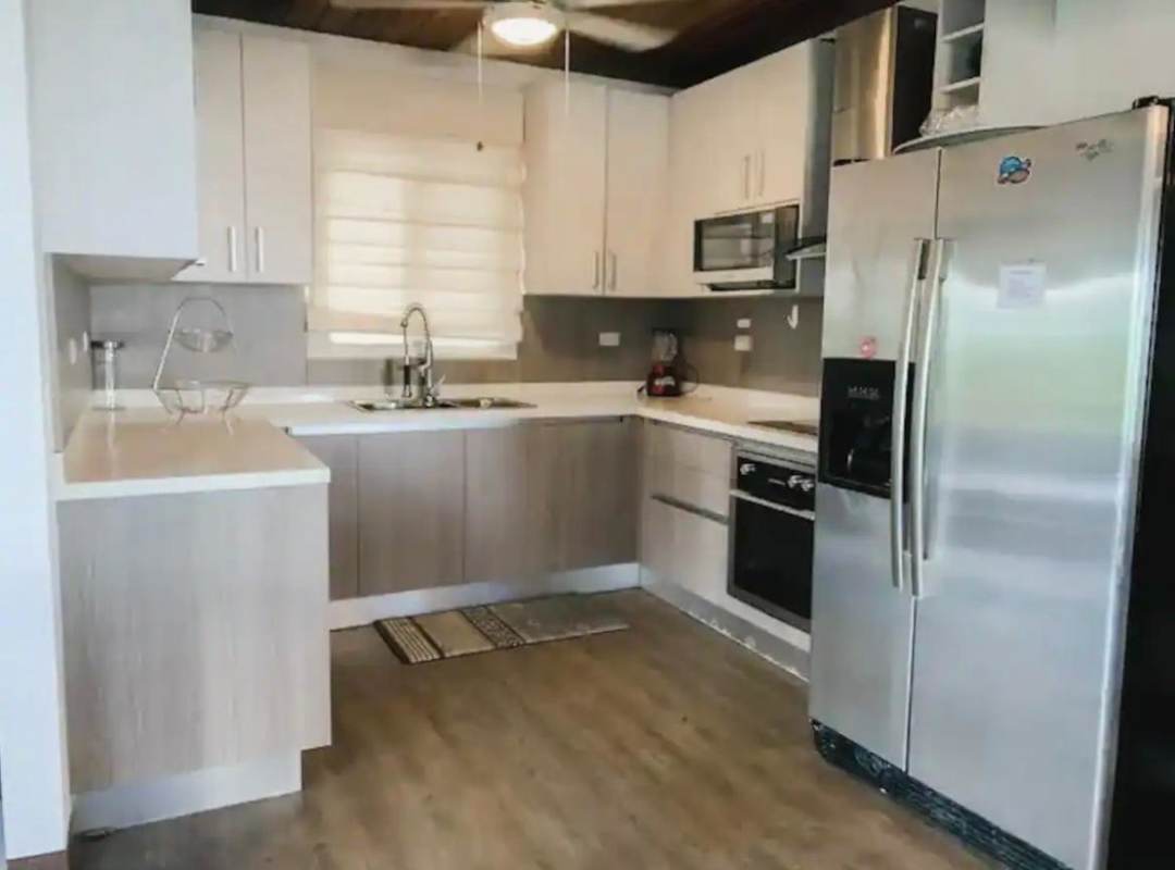 Rustic outdoor kitchen with granite countertop, wood bar, tropical garden setting Cerro Azul