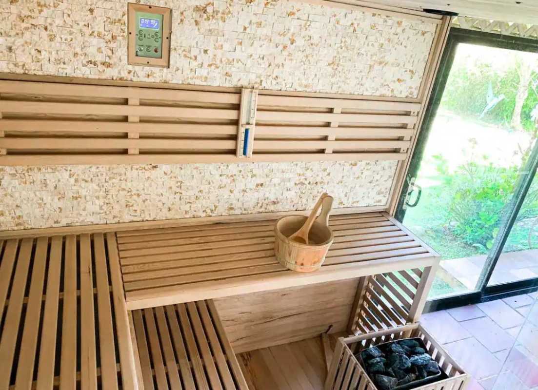 Modern indoor sauna with glass door and wooden benches overlooking gardens Cerro Azul Panama